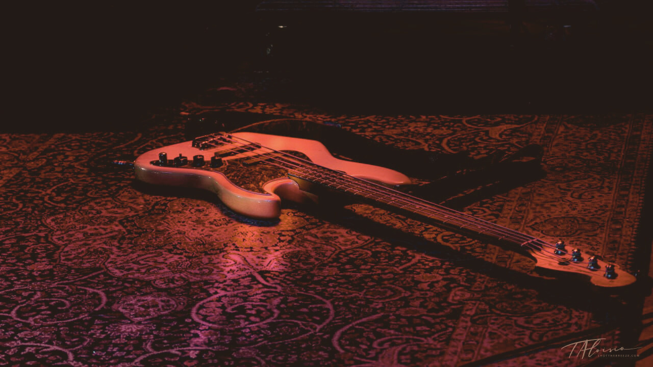 guitar laying on an ornate rug